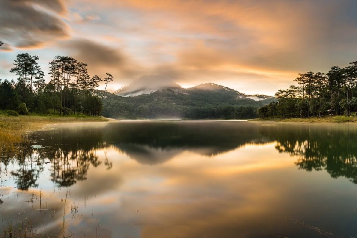 Tranquil Tuyen Lam Lake surrounded by pine forests under a blue sky